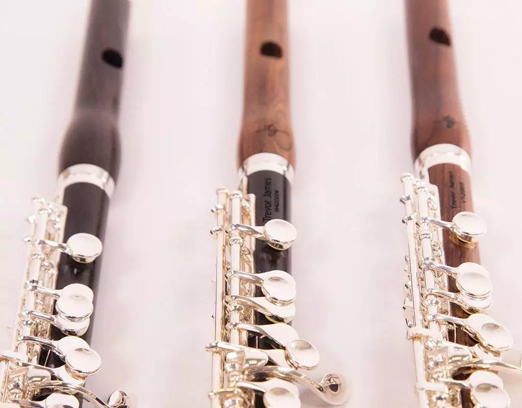 Three flutes, with a mix of medium-brown and darker brown hardwood.